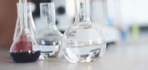 flask-with-blue-purple-pink-liquid-laboratory-cork-stand-table-test-laboratory-fluid-testing